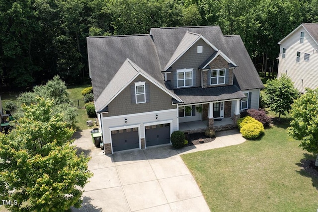 337 Shadowdale Ln, Rolesville, NC 27571 - craftsman-style home with driveway, stone siding, covered porch, a front lawn, and a garage