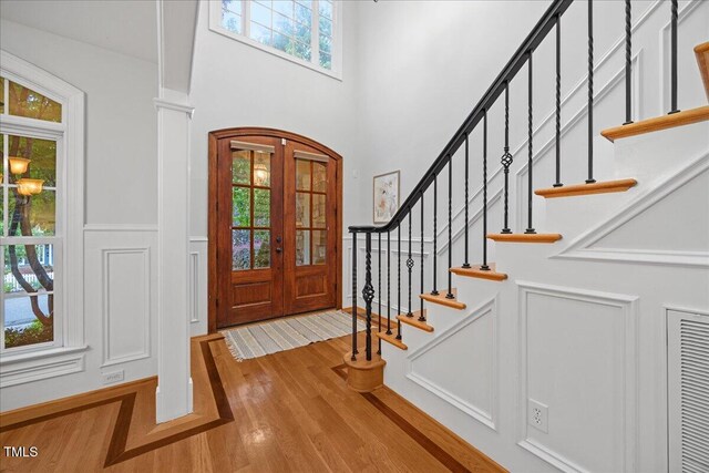 2507 Mayview Rd, Raleigh, NC 27607 - entrance foyer featuring wood finished floors, a wainscoted wall, stairway, a decorative wall, and arched walkways