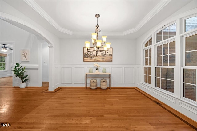2507 Mayview Rd, Raleigh, NC 27607 - unfurnished dining area featuring a chandelier, light wood-type flooring, ornamental molding, a decorative wall, and arched walkways