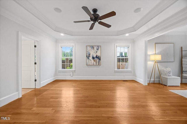 2507 Mayview Rd, Raleigh, NC 27607 - unfurnished living room featuring a tray ceiling, plenty of natural light, crown molding, light wood-type flooring, and a ceiling fan