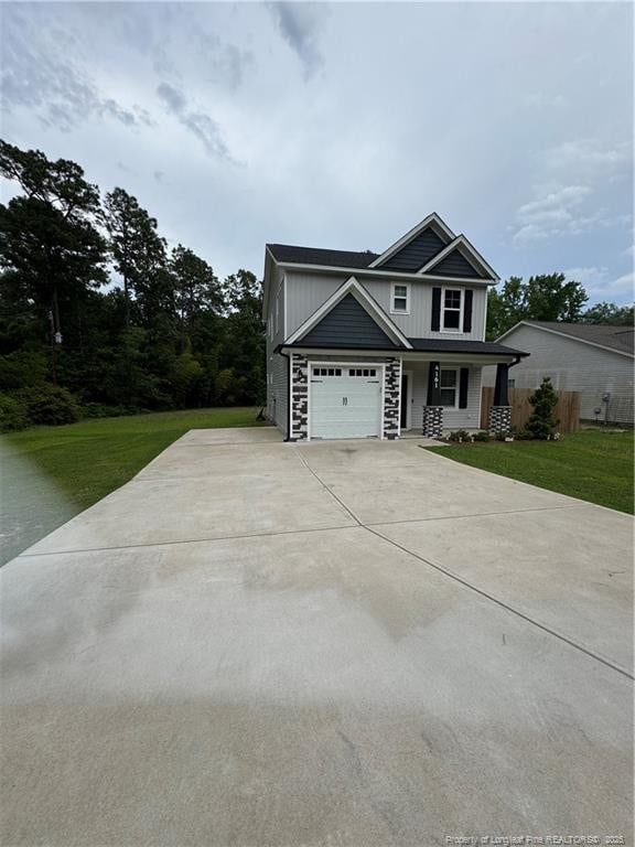 4161 Overhills Rd, Spring Lake, NC 28390 - view of front facade featuring concrete driveway, a porch, a front yard, and stone siding