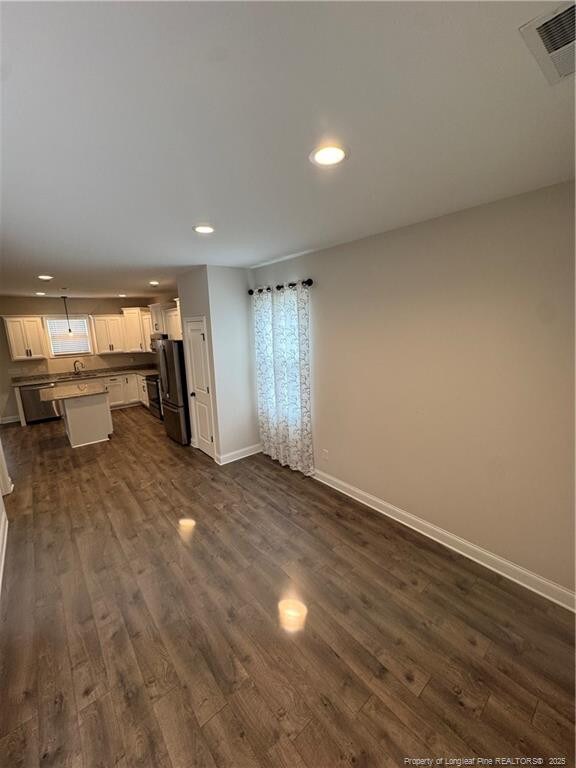 4161 Overhills Rd, Spring Lake, NC 28390 - unfurnished living room featuring dark wood-type flooring, recessed lighting, and baseboards