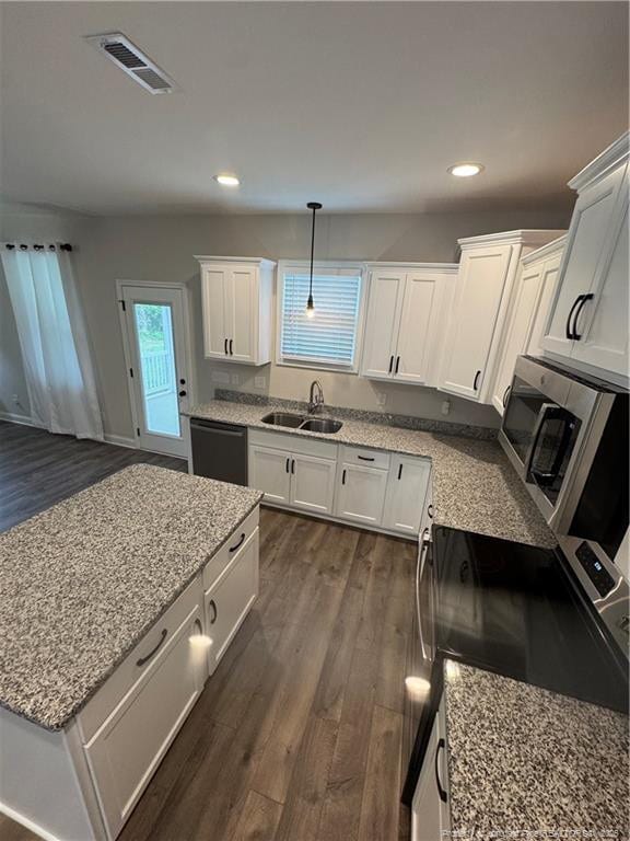 4161 Overhills Rd, Spring Lake, NC 28390 - kitchen with a sink, black dishwasher, dark wood finished floors, white cabinetry, and stainless steel microwave