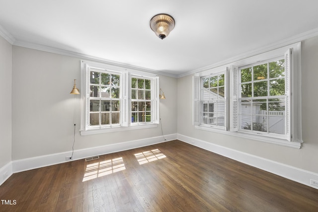 unfurnished room with baseboards, healthy amount of natural light, wood finished floors, and ornamental molding