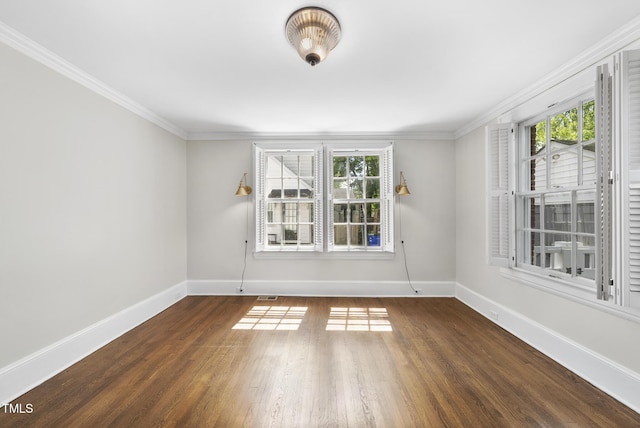 spare room with baseboards, healthy amount of natural light, wood finished floors, and crown molding