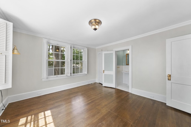 empty room with baseboards, wood finished floors, and ornamental molding