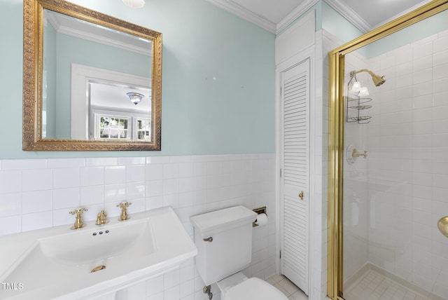 full bathroom featuring crown molding, a stall shower, toilet, tile walls, and wainscoting