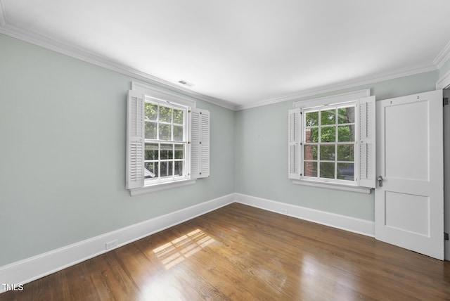unfurnished room featuring ornamental molding, baseboards, healthy amount of natural light, and wood finished floors