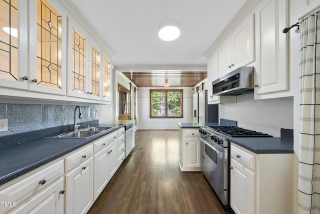 kitchen featuring stainless steel appliances, a sink, dark countertops, dark wood-style flooring, and white cabinetry