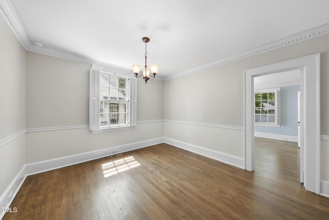unfurnished dining area with a chandelier, wood finished floors, ornamental molding, and baseboards