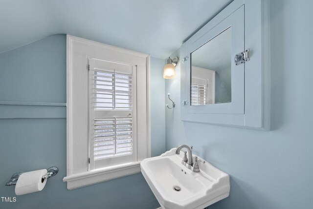 bathroom featuring a sink and vaulted ceiling