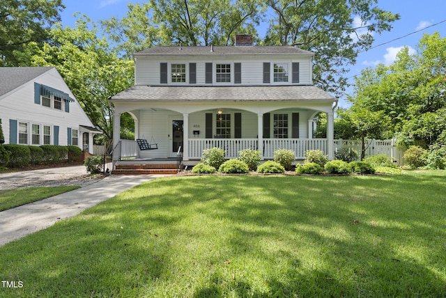 view of front facade featuring covered porch, a front lawn, a chimney, and roof with shingles