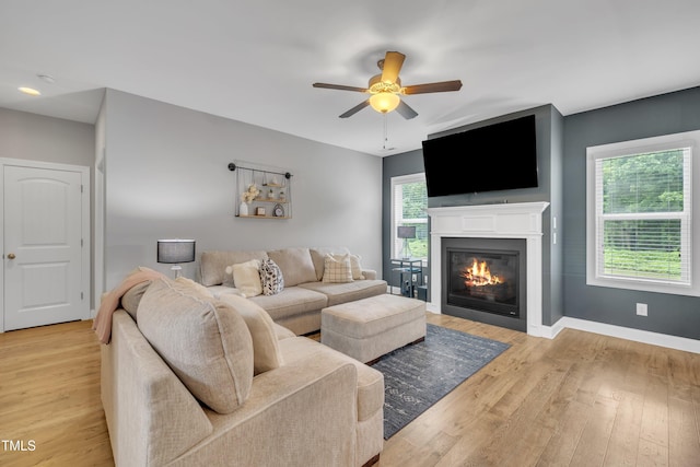 1109 Agio Ct, Zebulon, NC 27597 - living area with a ceiling fan, a glass covered fireplace, light wood finished floors, and baseboards