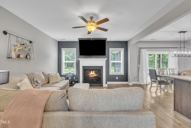 1109 Agio Ct, Zebulon, NC 27597 - living area with ceiling fan, wood finished floors, a glass covered fireplace, and baseboards