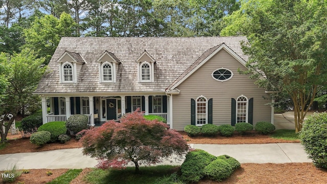 cape cod house featuring covered porch