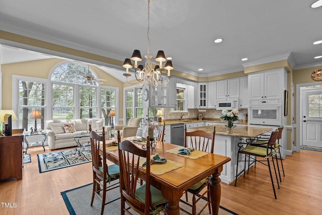 dining area with crown molding, light wood-style flooring, plenty of natural light, and recessed lighting
