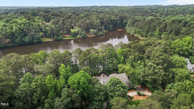 aerial view of property and surrounding area with a forest and a nearby body of water