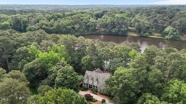 aerial view of property and surrounding area with a heavily wooded area and a large body of water