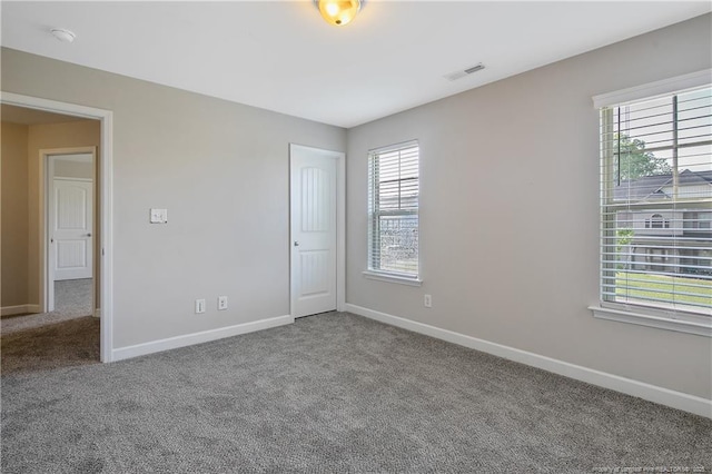empty room with carpet floors, baseboards, and a smoke detector