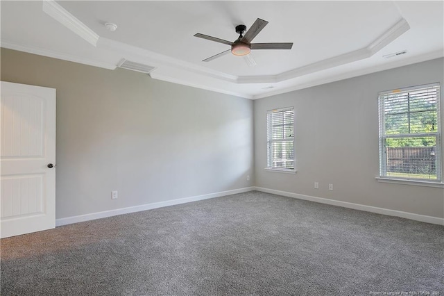 carpeted empty room with a tray ceiling, ornamental molding, ceiling fan, and baseboards