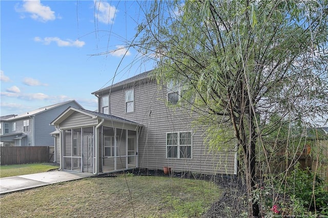rear view of house featuring a sunroom