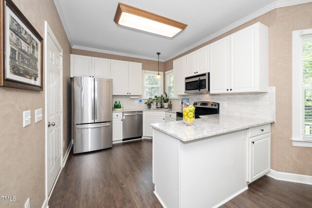 203 W Hill Dr, Cary, NC 27519 - kitchen featuring appliances with stainless steel finishes, a peninsula, dark wood-type flooring, tasteful backsplash, and white cabinetry
