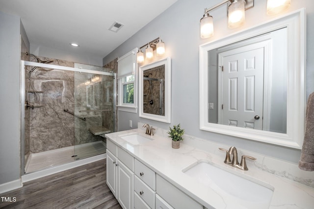 203 W Hill Dr, Cary, NC 27519 - bathroom with double vanity, a shower stall, wood finished floors, and recessed lighting