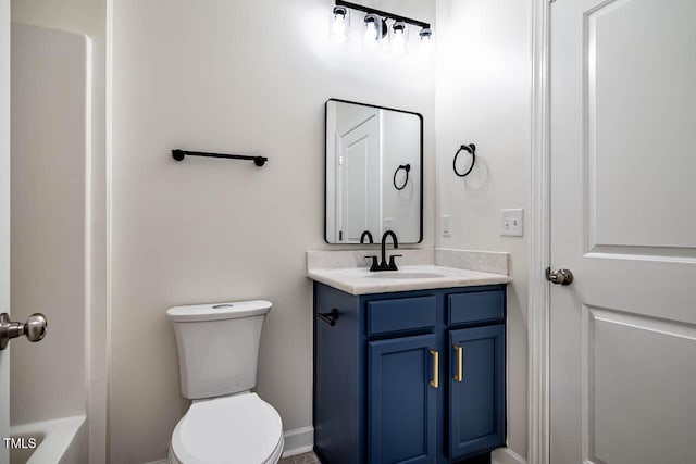 bathroom featuring toilet, vanity, and a bath