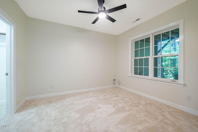 carpeted empty room with baseboards and a ceiling fan
