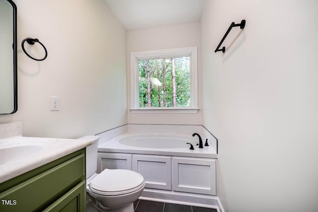 bathroom with tile patterned floors, vanity, a garden tub, and toilet