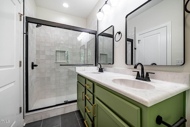 bathroom with a shower stall, double vanity, and tile patterned floors