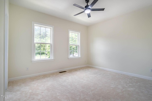 carpeted spare room featuring baseboards and ceiling fan