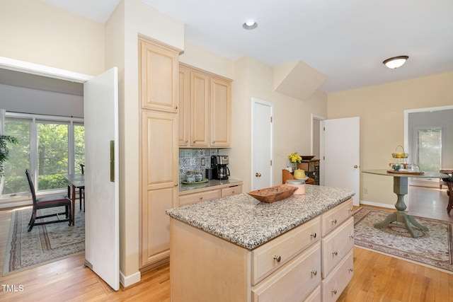 203 Old Forest Creek Dr, Chapel Hill, NC 27514 - kitchen with light brown cabinets, light wood-type flooring, light stone counters, a kitchen island, and baseboards