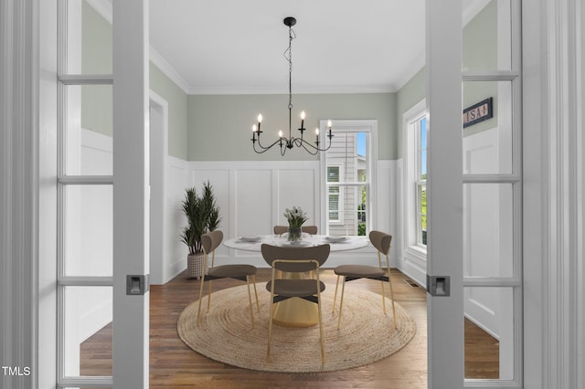 1423 Tannin Dr, Durham, NC 27713 - dining room with a decorative wall, a chandelier, ornamental molding, wood finished floors, and wainscoting