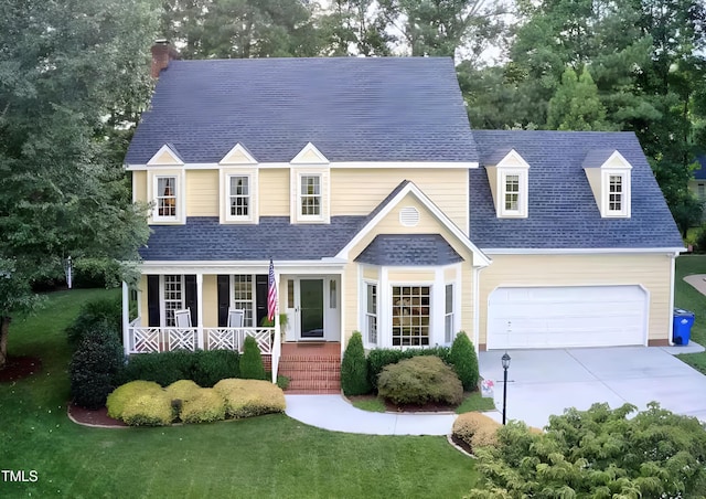 view of front of property with a porch, a front yard, roof with shingles, driveway, and a chimney