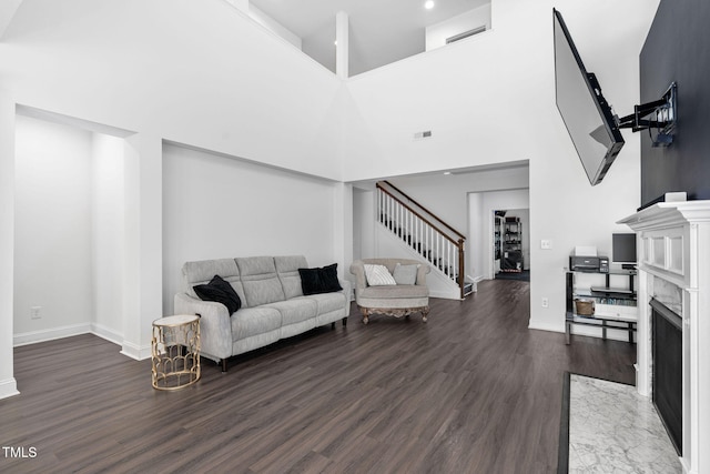 310 Alamosa Pl, Cary, NC 27519 - living room featuring stairway, dark wood finished floors, a premium fireplace, baseboards, and a towering ceiling