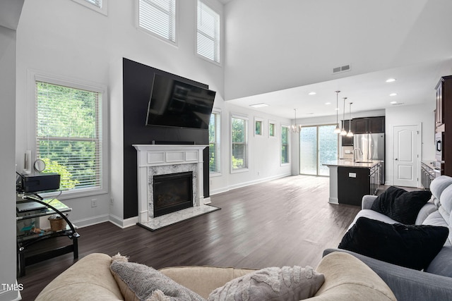 310 Alamosa Pl, Cary, NC 27519 - living area with dark wood-type flooring, a premium fireplace, baseboards, a towering ceiling, and recessed lighting