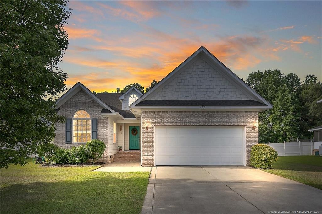 199 Thorncliff Dr, Raeford, NC 28376 - view of front of house with driveway, a garage, and brick siding