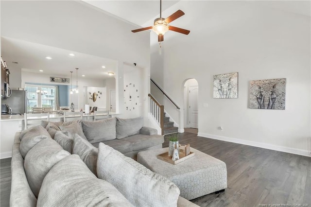 living area with a ceiling fan, arched walkways, dark wood-style floors, stairs, and recessed lighting