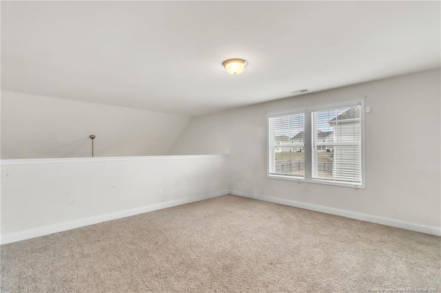 additional living space with carpet, baseboards, and vaulted ceiling