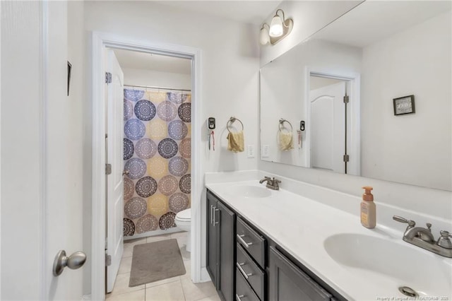 full bathroom with double vanity, tile patterned flooring, and toilet