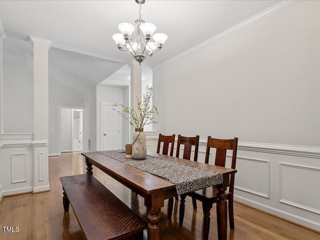 1662 Beechaven Rd, Fuquay Varina, NC 27526 - dining room featuring light wood-style flooring, a chandelier, ornate columns, a decorative wall, and crown molding