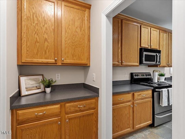1662 Beechaven Rd, Fuquay Varina, NC 27526 - kitchen featuring stainless steel appliances, dark countertops, and brown cabinetry