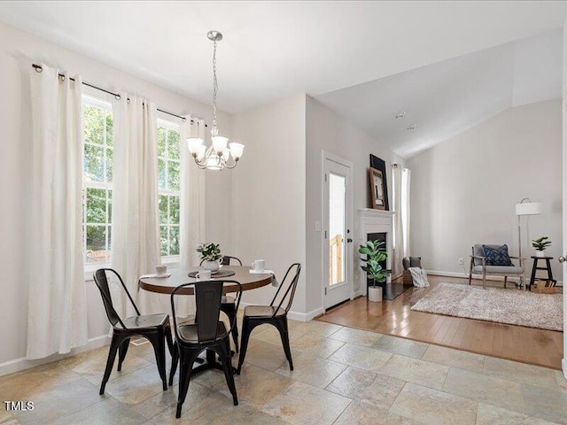 1662 Beechaven Rd, Fuquay Varina, NC 27526 - dining room with baseboards, a chandelier, stone tile floors, and a fireplace