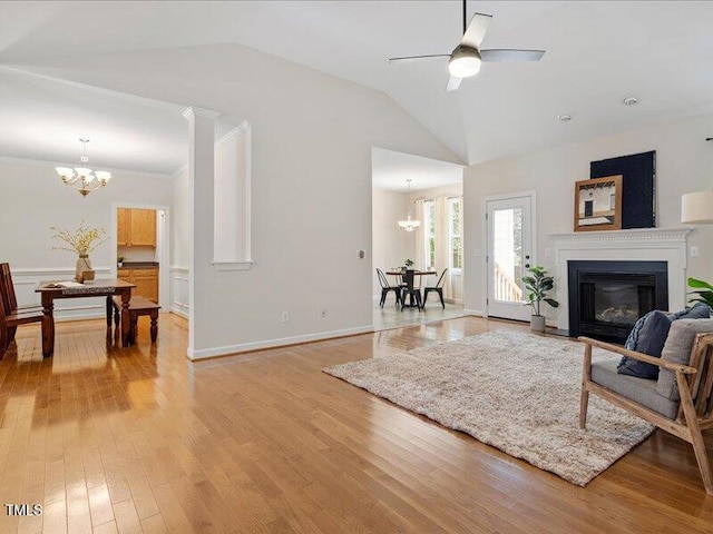 1662 Beechaven Rd, Fuquay Varina, NC 27526 - living area featuring a chandelier, light wood-type flooring, vaulted ceiling, a glass covered fireplace, and a ceiling fan