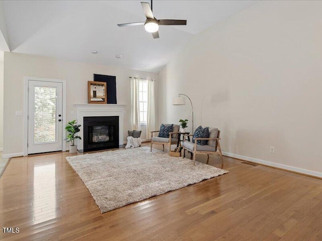 1662 Beechaven Rd, Fuquay Varina, NC 27526 - living room with ceiling fan, light wood-style floors, high vaulted ceiling, a glass covered fireplace, and baseboards