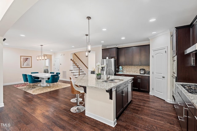200 Vintage Hill Cir, Apex, NC 27539 - kitchen featuring a sink, an island with sink, ornamental molding, stainless steel appliances, and dark brown cabinets
