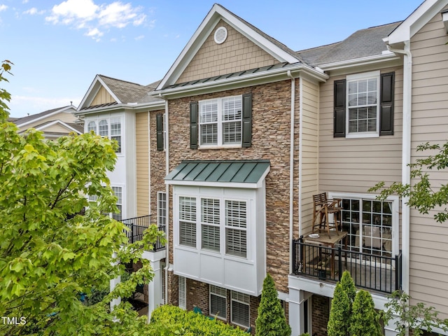 9164 Wooden Rd, Raleigh, NC 27617 - view of front of house with stone siding, a standing seam roof, and metal roof