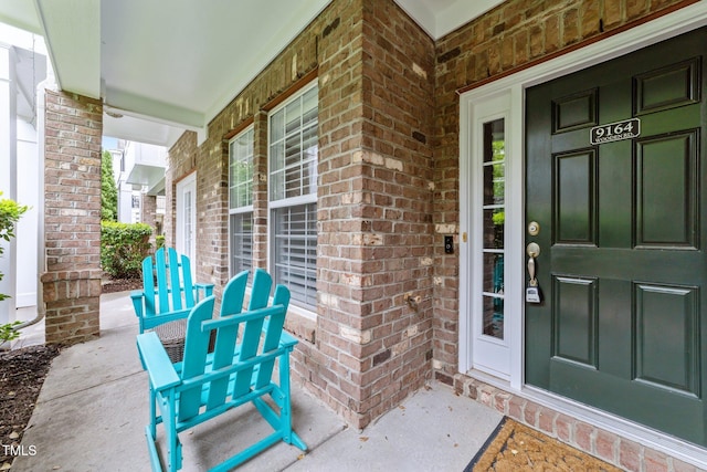 9164 Wooden Rd, Raleigh, NC 27617 - view of exterior entry featuring a porch and brick siding