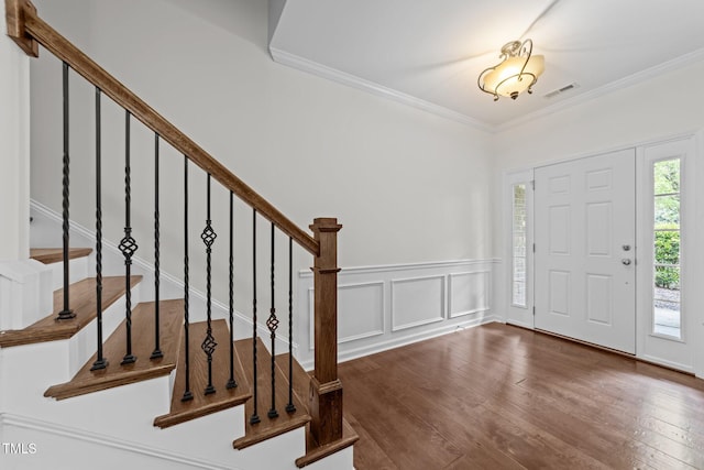 9164 Wooden Rd, Raleigh, NC 27617 - entrance foyer featuring wood-type flooring, crown molding, stairs, a decorative wall, and wainscoting